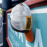 Polynesian Cultural Center Rough Cut Contrast Ball Cap Hanging from a hook