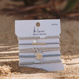 K'lani "Wonder" Wrist and Hair Tie Bracelets Set- on package staged in the sand