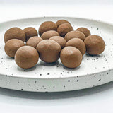 Ahualoa Milk Chocolate Covered Macadamia Nuts shown on dish.