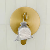 Shower Steamer Honey+Almond hanging from a shower faucet control