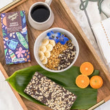 Hawaiian Host "Surfer's Breakfast" Dark Chocolate Bar on tray with coffee, fruit and granola