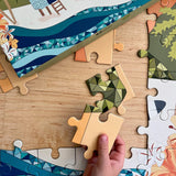 A person assembling a Surf Shack "Stay a While" Kid's 70-piece Puzzle