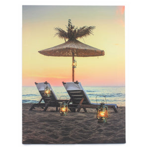 Wall Art of two beach chairs facing towards the ocean at the beach with a umbrella above them for shade and lanterns around it to give the image a unique display